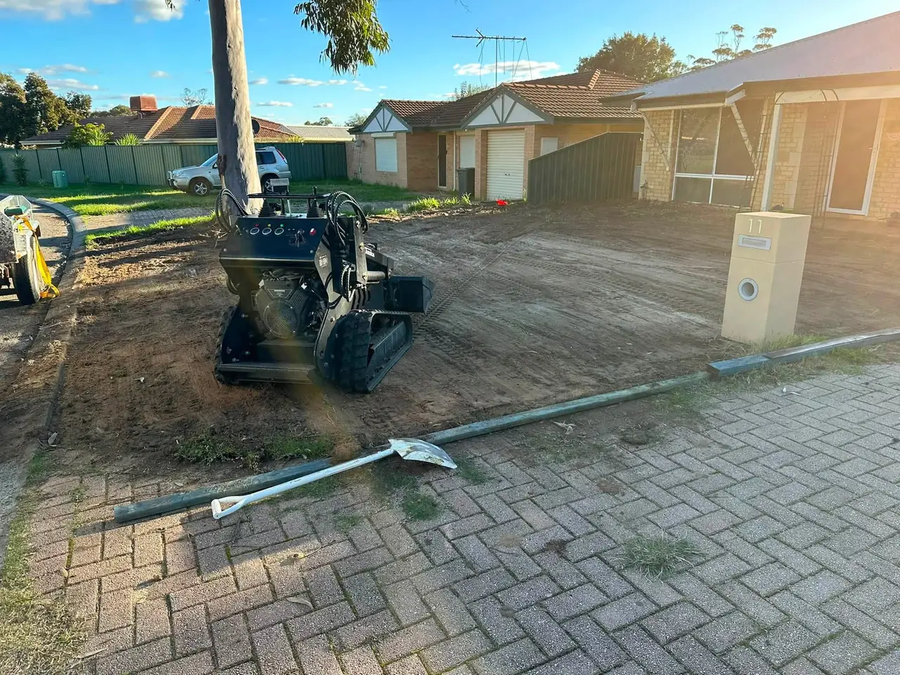 Bullsbrook front yard stripped back to clean dirt, mini loader parked beside the paving
