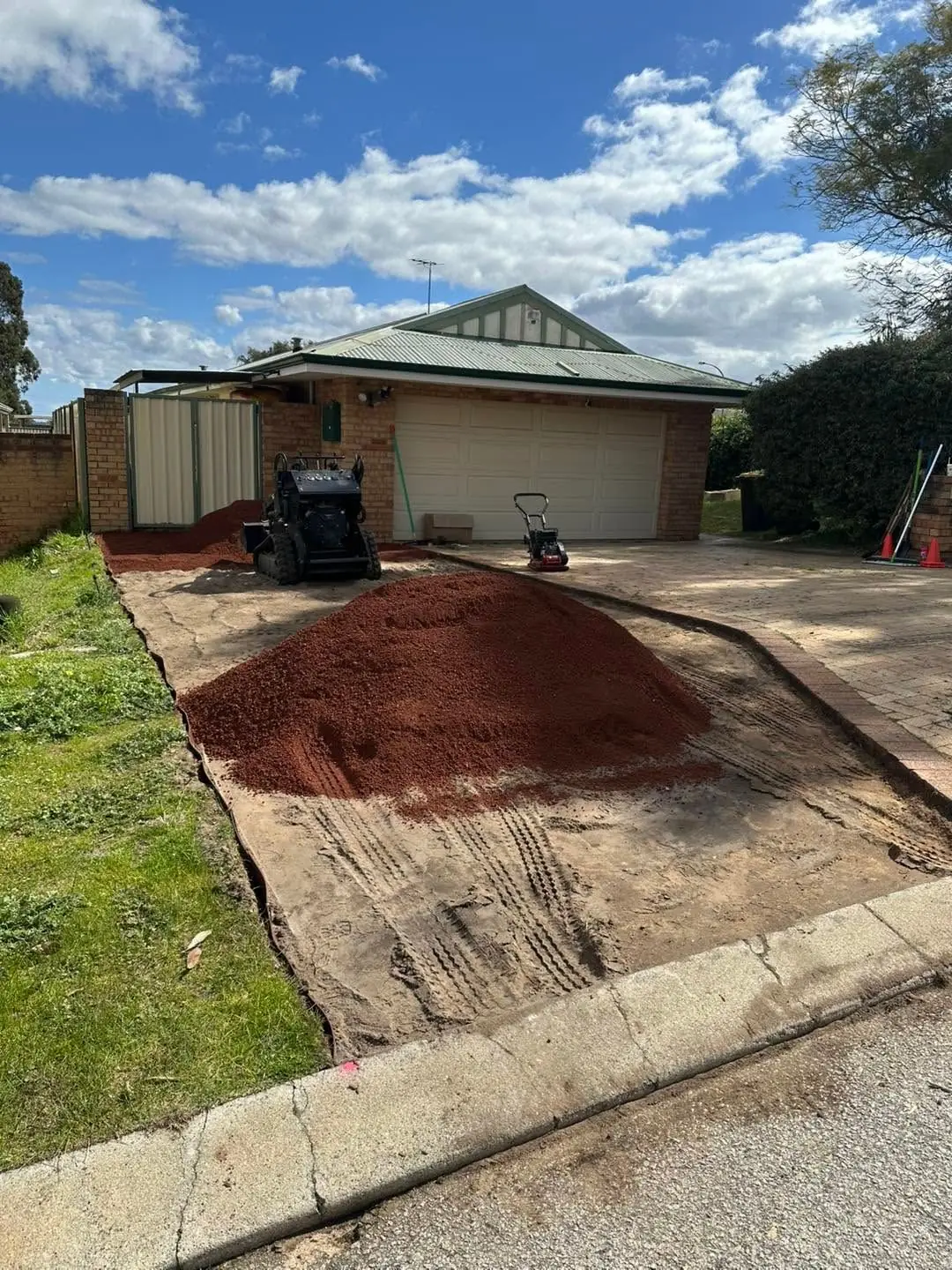 Pile of red road gravel dropped on the prepared hardstand area