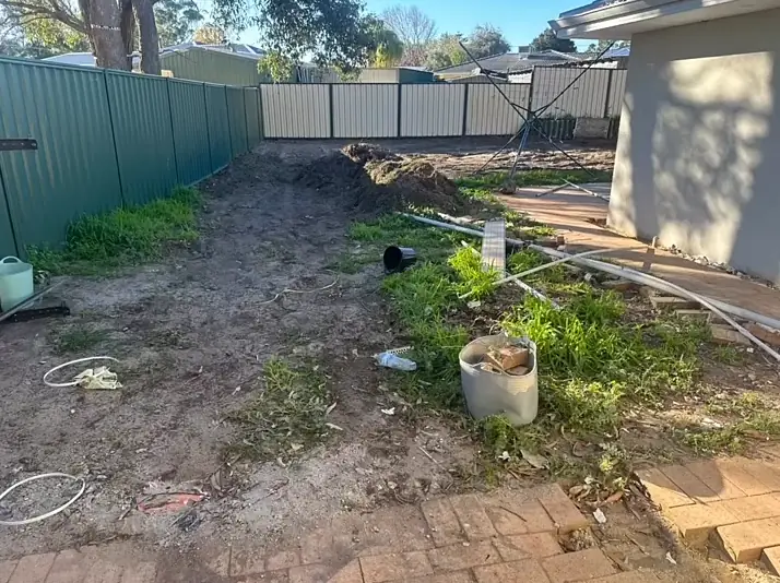 Side yard full of weeds, old pots and rubbish before the clean up