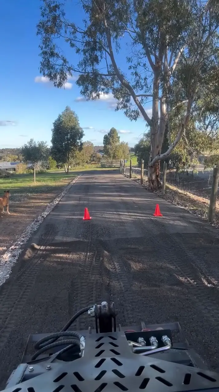 Operator's view laying a long rural driveway with the mini loader